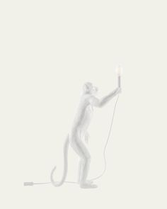 a white monkey holding a light up in the air with it's tail extended