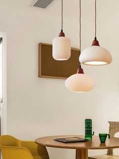 three lamps hanging from the ceiling above a table