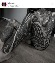 a man with tattoos laying on the floor