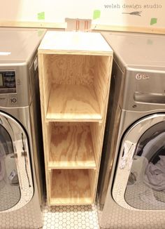 the washer and dryer are next to each other in front of some shelves