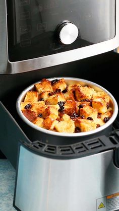 a pan filled with food sitting on top of an oven next to a toaster