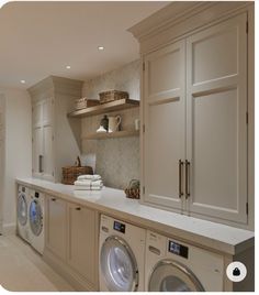 a washer and dryer in a room with cabinets on either side of it