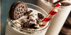 an oreo cookie and milkshake in a glass with a red striped straw