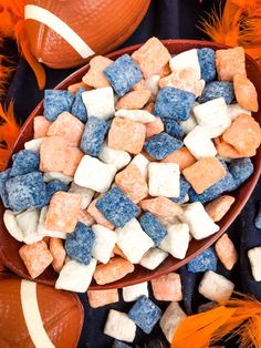 a bowl filled with marshmallows and blueberries next to an orange football