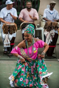 a woman in a colorful dress dancing with other people