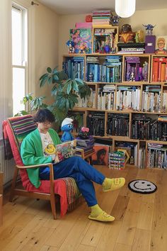 a person sitting on a chair in front of a bookshelf filled with books