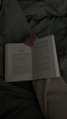 a person laying in bed reading a book