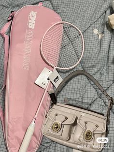 a purse, tennis racket and other items on a bed