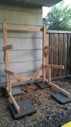 a wooden bench sitting in the middle of a yard next to a fence and building