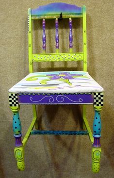 a wooden chair with purple and green designs on it