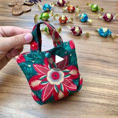 a person is holding a small purse on a table with many candy candies in the background