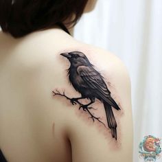 a woman's shoulder with a black bird on the tree branch and watercolor paint