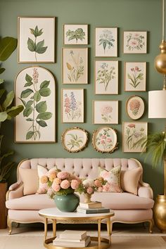 a living room with green walls and pictures on the wall above the pink couches