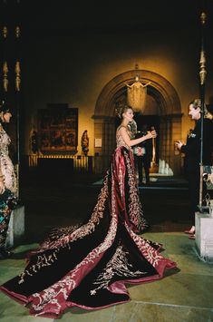 a woman in an elaborate dress standing next to a man