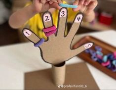 a child is holding up a hand made out of cardboard with numbers on the fingers