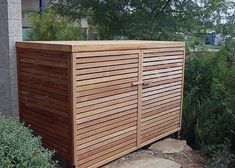 a wooden storage box sitting in the middle of a garden