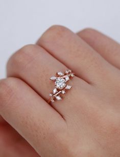 a woman's hand with a diamond ring on top of her finger and the other hand holding it