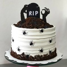 a halloween cake with white frosting and black decorations