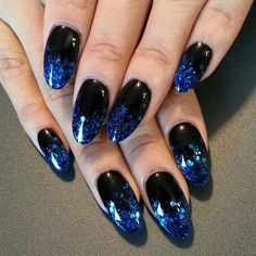 blue and black nails with glitter on them