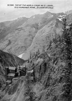 an old black and white photo of a mountain with houses on the side of it