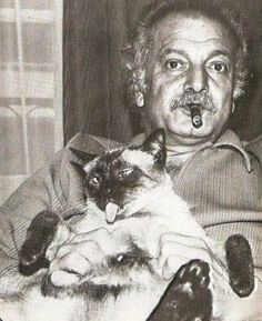 an old man holding a cat in his lap with a pipe sticking out of it's mouth