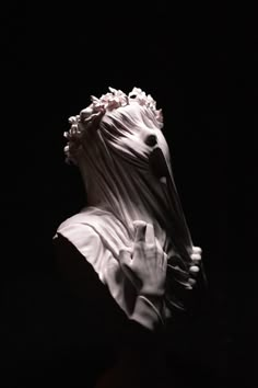 a statue of a woman with her hands on her face, in the dark background