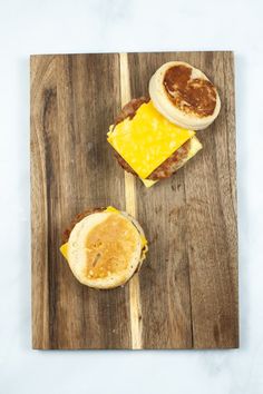 two breakfast sandwiches on a wooden cutting board