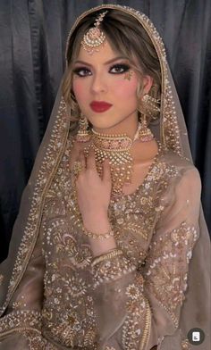 a woman wearing a bridal outfit and jewelry