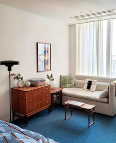 a living room with a couch, coffee table and lamp in it's corner