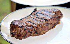 a piece of steak sitting on top of a white plate