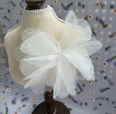 a mannequin with white tulle and beading on it's head