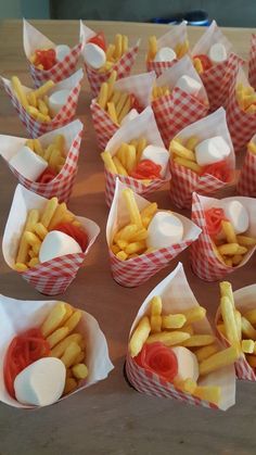 many small baskets filled with french fries on top of a wooden table next to each other