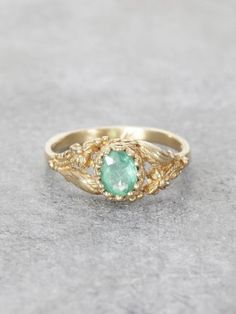 A lush Golden Garden of delicately detailed wildflowers and gracefully winding leaves, reveals a precious, crowned Emerald jewel set in Solid 14K Gold. This would make an exceptional & unique Engagement Ring. Additional gems are also available by request. This extra fine beautiful quality Colombian Emerald measures 6x5.5mm and is approx. .65ct. Ring measures 7.5mm at the front, tapering to a 1.8 mm band. Handcrafted with Love by Elise Perelman in NYC.  We recommend double-checking your ring size Elegant Green Oval Flower Ring, Heirloom Style Yellow Gold Oval Flower Ring, Nature-inspired 14k Gold Oval Jewelry, Nature-inspired Oval 14k Gold Jewelry, 14k Gold Nature-inspired Oval Jewelry, Elegant May Birthstone Flower Ring With Gemstone, Oval 14k Gold Nature-inspired Jewelry, Nature-inspired 14k Gold Formal Jewelry, Formal Nature-inspired 14k Gold Jewelry