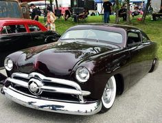 two classic cars parked next to each other