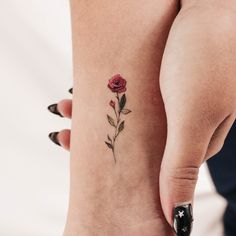 a woman's foot with a small rose tattoo on the left side of her leg