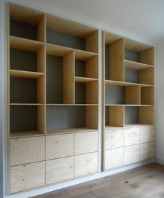 an empty room with some wooden shelves and drawers on the wall next to each other