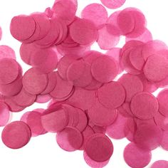 pink felt circles are scattered on a white surface