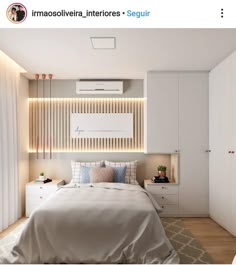 a bedroom with white walls and wooden flooring is lit by recessed lighting above the bed