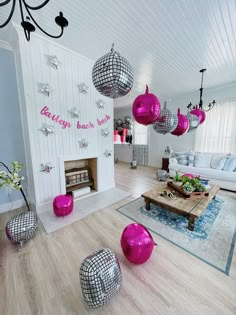 a living room filled with lots of furniture and balloons hanging from the ceiling in front of a fire place