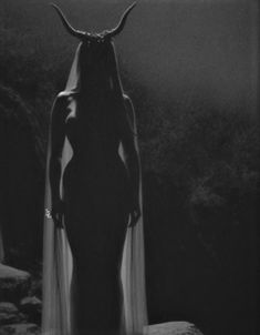 a woman with horns standing in the dark