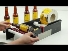 a person using a machine to make beer bottles