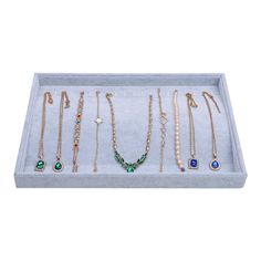 an open box with several different necklaces and earrings in it on a white background