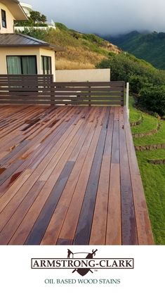 a wooden deck in front of a house with mountains in the backgroung