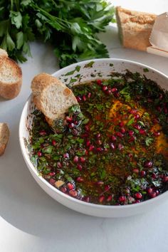 a white bowl filled with greens and bread