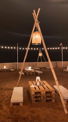 a wooden structure made out of pallets with lights on the roof and some benches around it