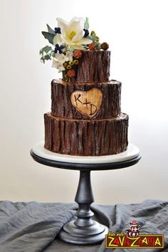 a three tiered cake decorated with wood and flowers