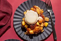 a plate topped with waffles covered in ice cream next to a fork and napkin