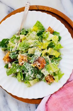 a white plate topped with a salad covered in lettuce