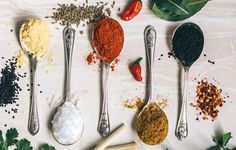 five spoons with different types of spices on them