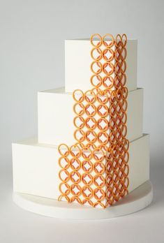 three tiered white cake with orange circles on top